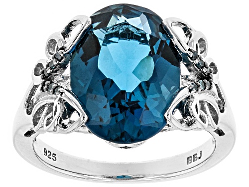 6.28CT OVAL LONDON BLUE TOPAZ WITH .04CTW BLUE DIAMOND ACCENT RHODIUM OVER SILVER RING - Size 9