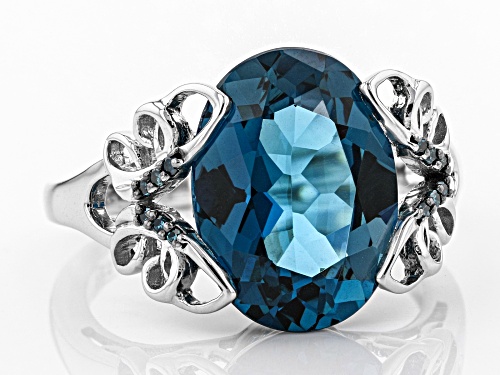 6.28CT OVAL LONDON BLUE TOPAZ WITH .04CTW BLUE DIAMOND ACCENT RHODIUM OVER SILVER RING - Size 9