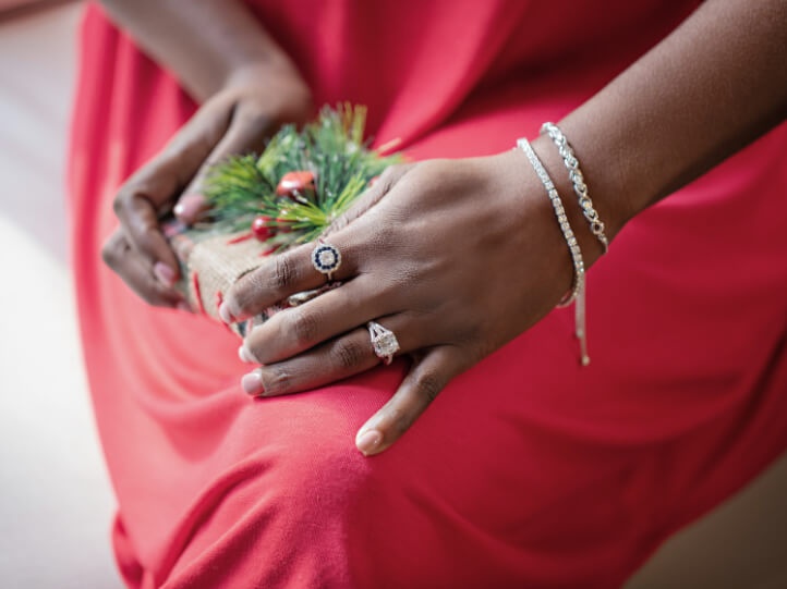 Woman wearing pearl jewelry holding a wreath