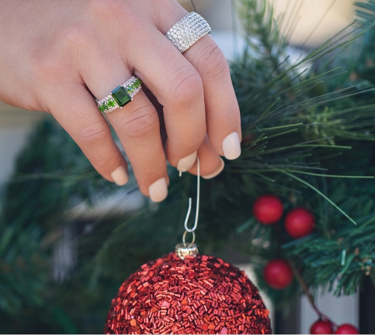 Woman wearing jewelry while decorating a Christmas tree