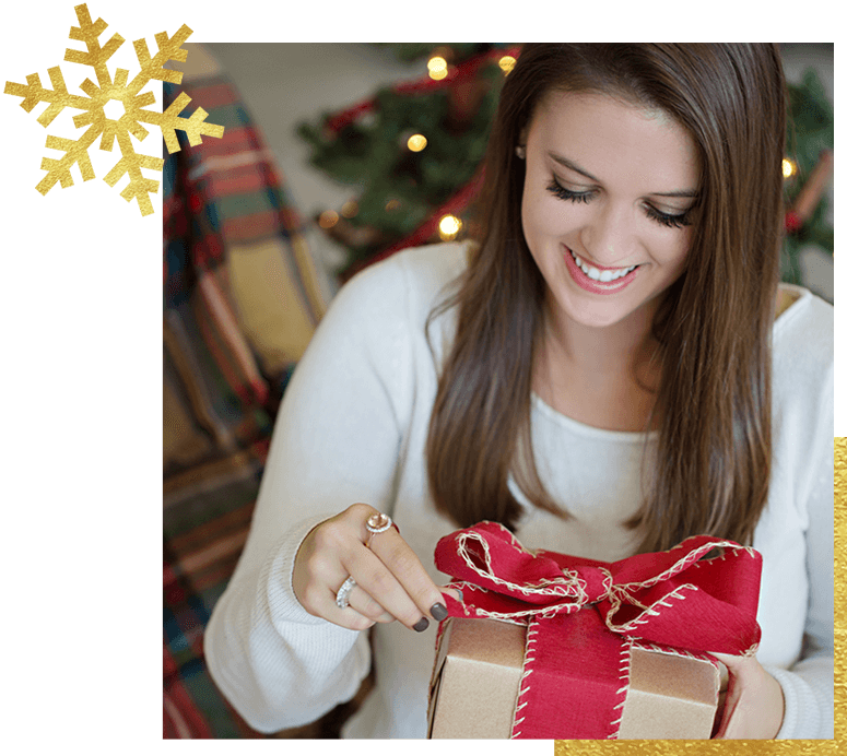 Woman wearing jewelry opening a holiday gift 