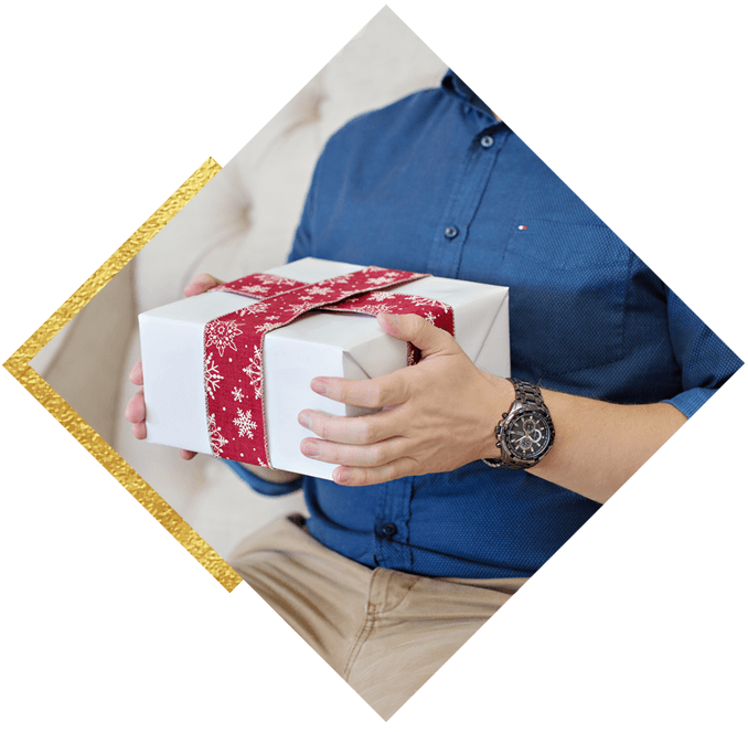 Man wearing a watch holding a holiday gift 